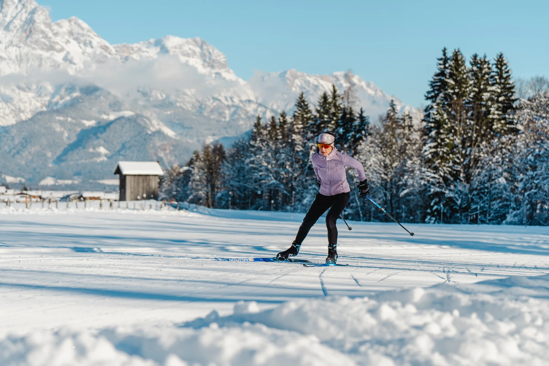 Langläufer auf WM-Loipe mit Hütte und Steinberge im Hintergrund