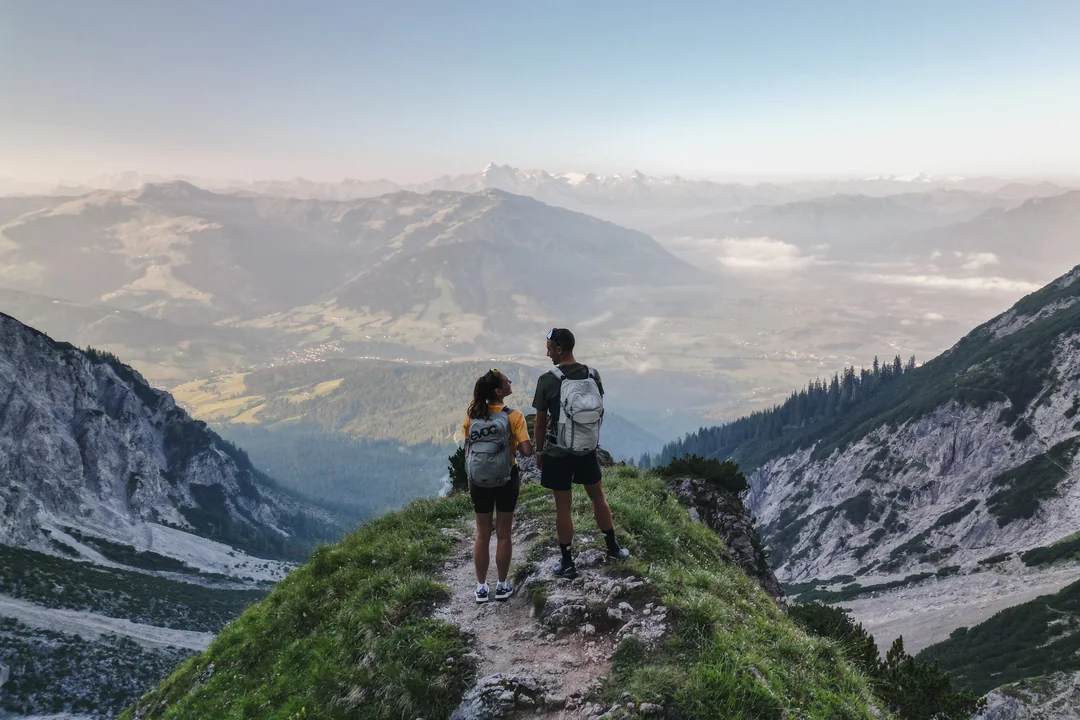 Hiking couple on mountain ridge with wide Steinberge panorama