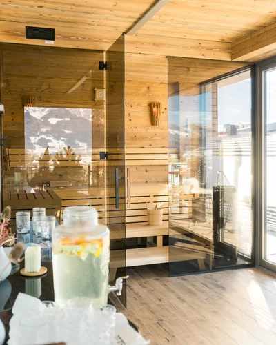 Glasfront-Sauna mit Infused Water Karaffe und Blick auf die Terrasse