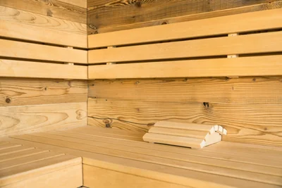 Sauna-Innenraum mit hellen Holzbänken und ergonomischer Kopfstütze