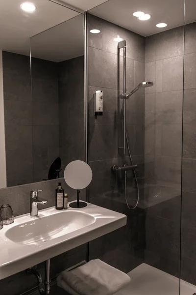 Modernes Badezimmer mit grauen Fliesen, ebenerdiger Dusche und schwebendem Waschtisch