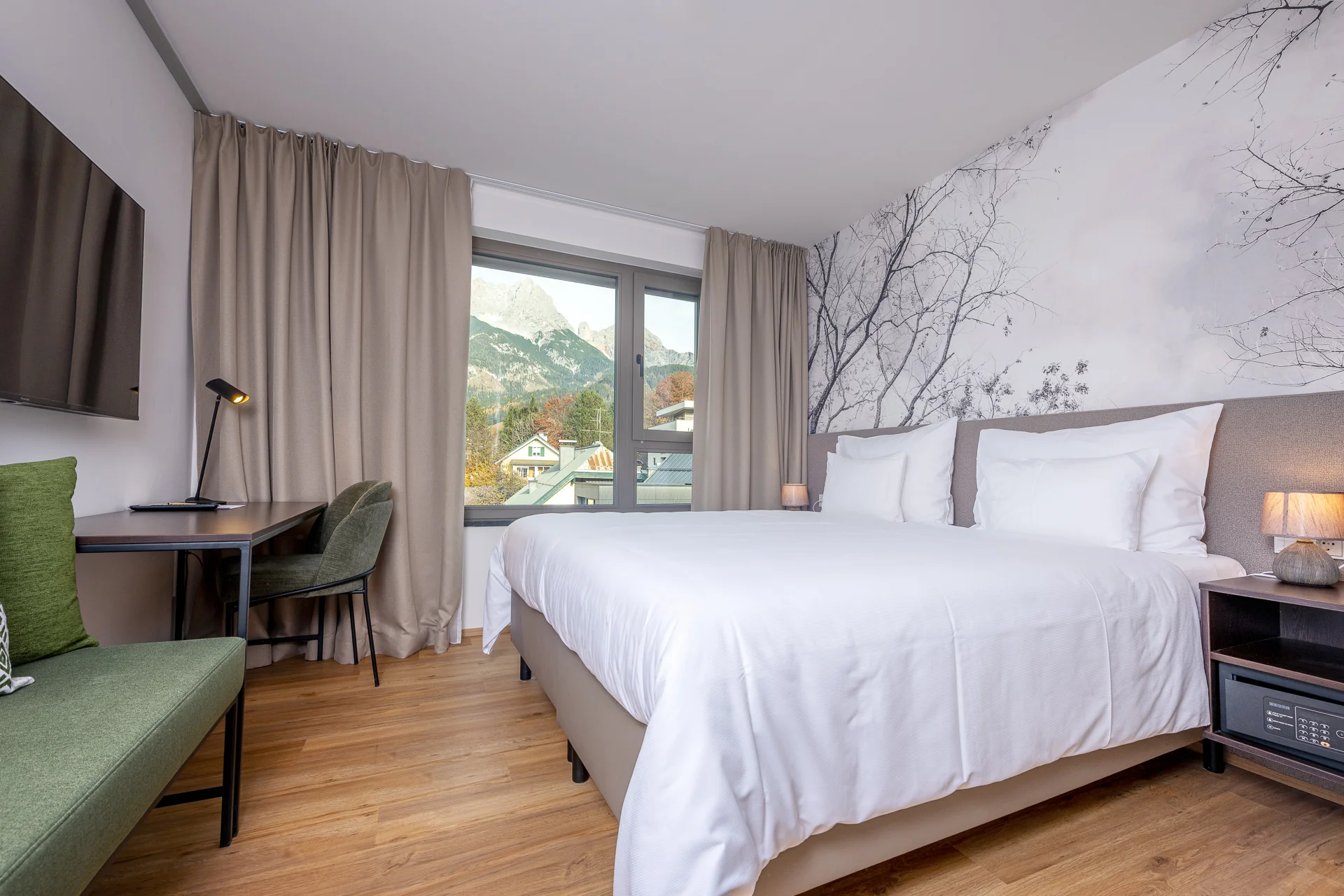 Doppelzimmer mit Baumzweig-Wandmotiv und herrlichem Steinberge-Blick durch den Balkon