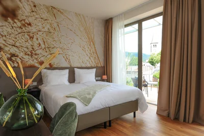 Executive Suite mit Blick auf den Saalfeldener Kirchturm durch die Balkontür