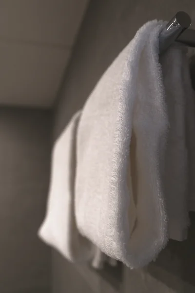 Flauschiges weißes Handtuch am chromglänzenden Handtuchhalter im Badezimmer
