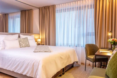 Lichtdurchflutetes Elternschlafzimmer mit komfortablem Doppelbett und integriertem Arbeitsplatz