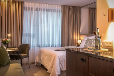 Schlafbereich der Family Suite mit Blick auf Bett und stilvoller Minibar-Konsole mit Wassergläsern