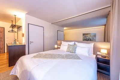 Elternschlafbereich der Family Suite mit Doppelbett, LED-Deckenbeleuchtung und Minibar