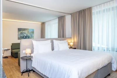 Helles Schlafzimmer der Family Suite mit Doppelbett und charakteristischem Oldtimer-Gemälde