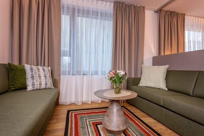 Wohnbereich der Family Suite mit Sofas, Raumteiler und historischem Oldtimer-Gemälde