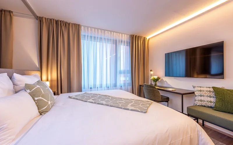 Geraeumige Family Suite mit Doppelbett, TV-Wand und Sitzbereich