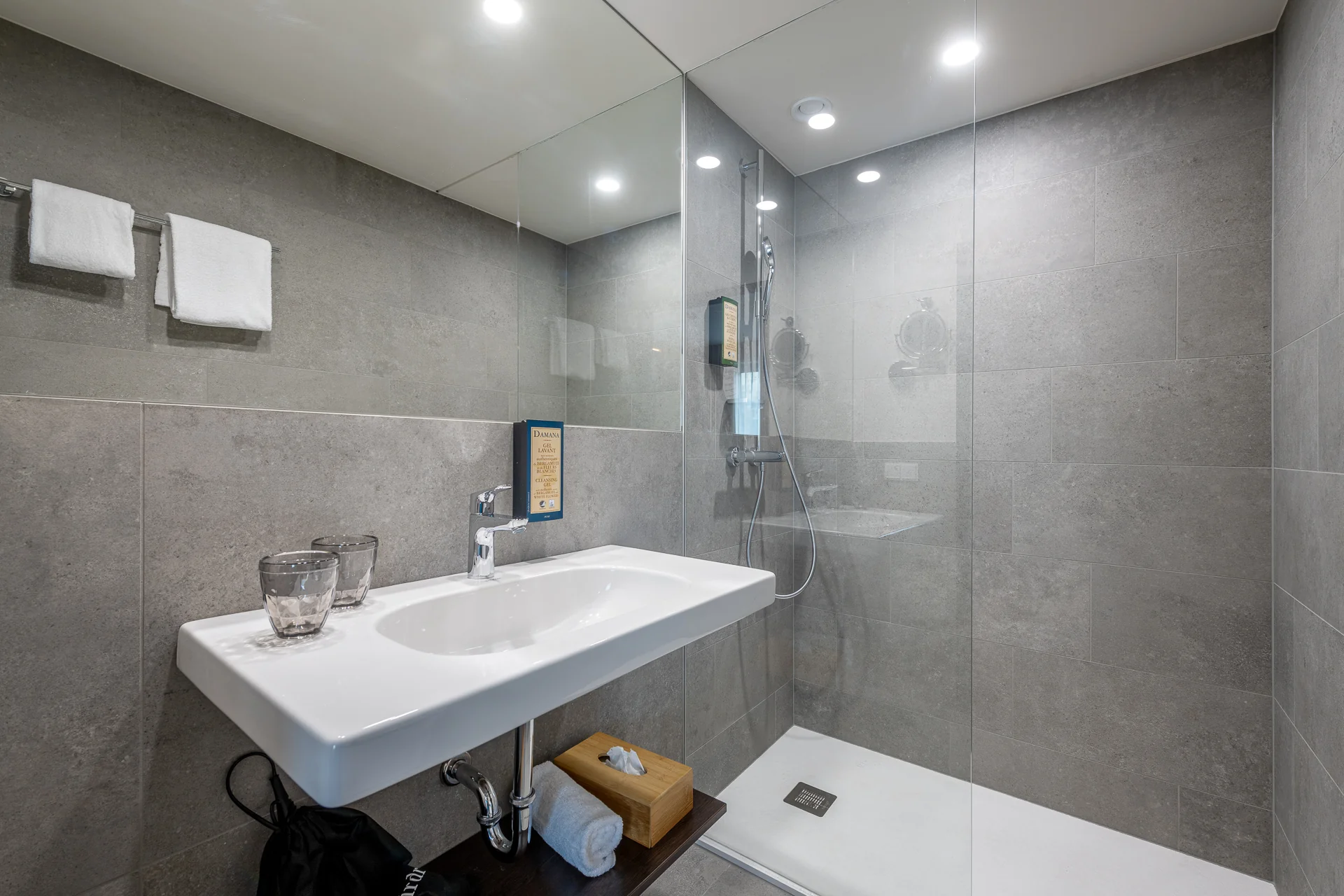 Elegantes Badezimmer mit grauen Natursteinfliesen, Regendusche und schwebendem Waschtisch