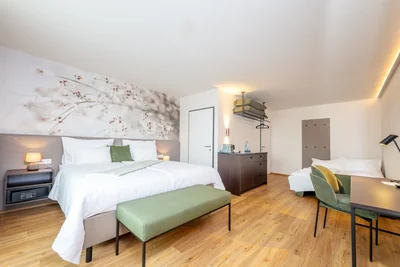 Großzügige Junior Suite mit Blütentapete, Tagesbett, Schreibtisch und Minibar-Regal