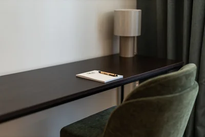 Eleganter Schreibtisch mit Notizblock, Stift und zylindrischer Tischlampe