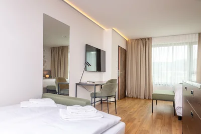 Sitzbereich mit Tagesbett, Ganzkörperspiegel und TV-Wand mit Schreibtisch