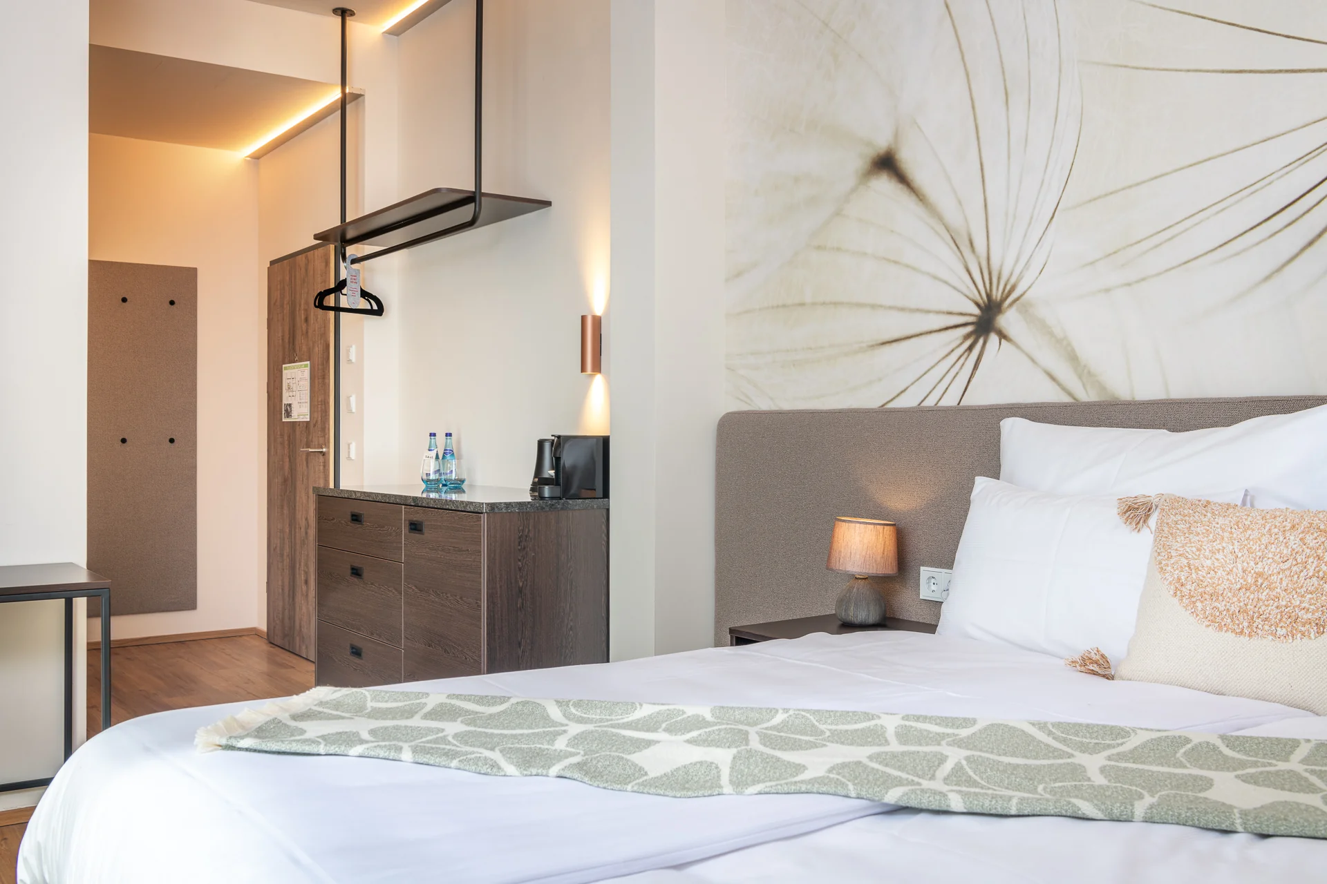 Schlafzimmer mit Pusteblumen-Tapete, Minibar und grüner Decke