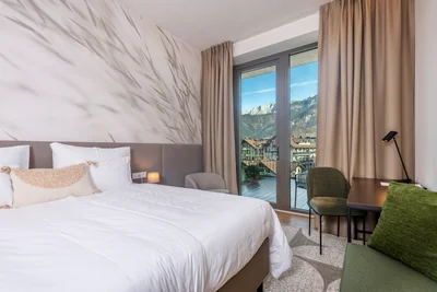 Premium Suite Schlafzimmer mit Gräser-Tapete und Balkon