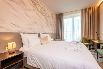 Premium Suite mit zartem Gräser-Wandmotiv, grauem Sessel und Bergblick