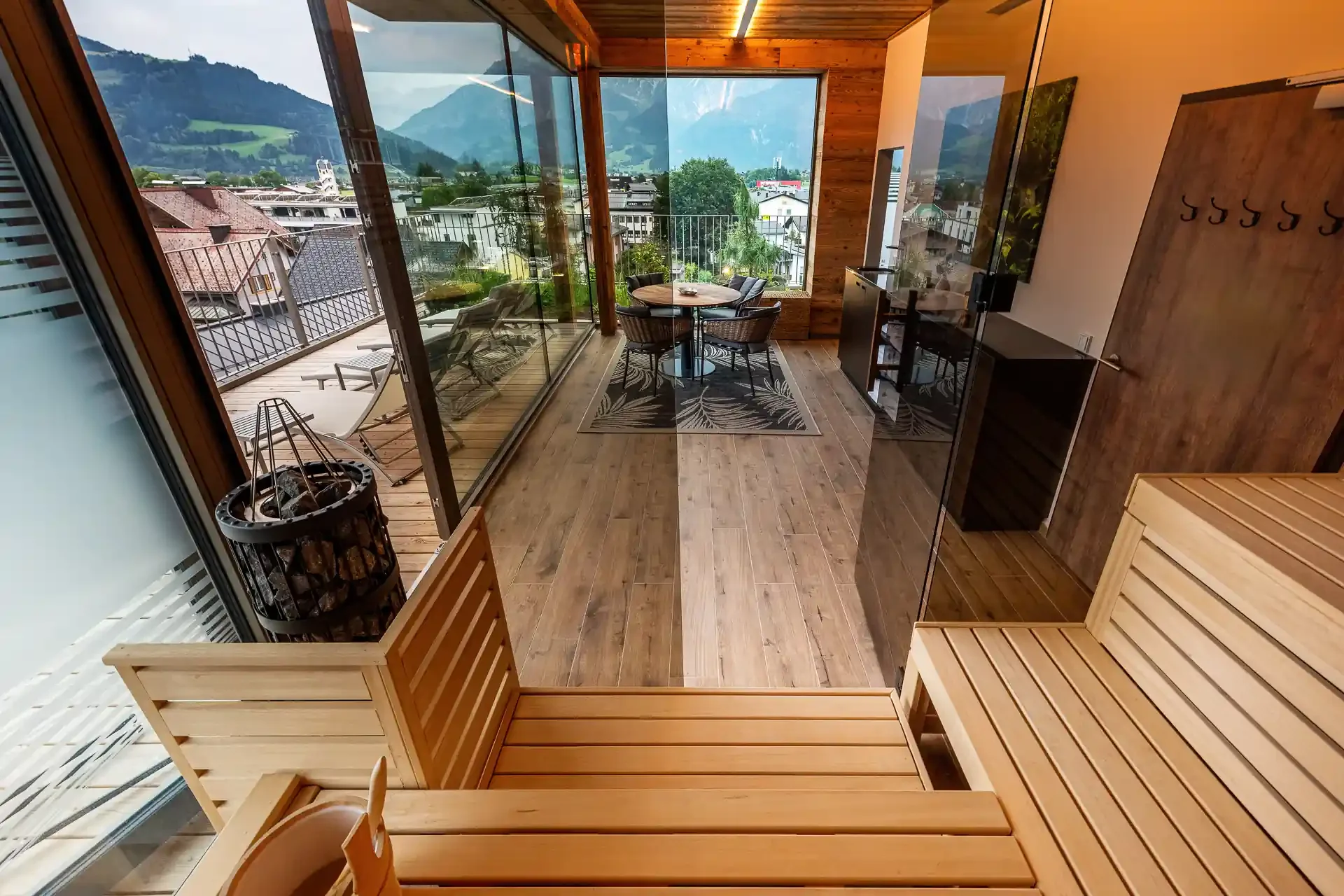 Blick aus der Sauna auf Terrasse und Ruhebereich mit Bergpanorama