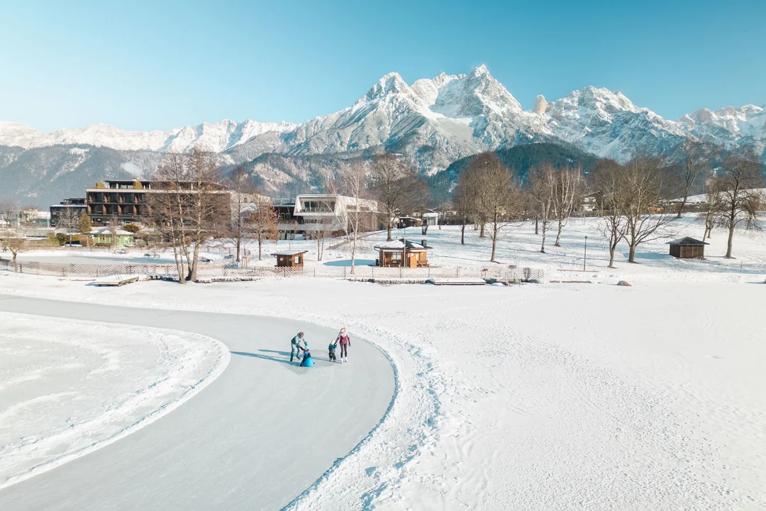 Familie beim Eislaufen am Ritzensee mit den Steinbergen im Hintergrund