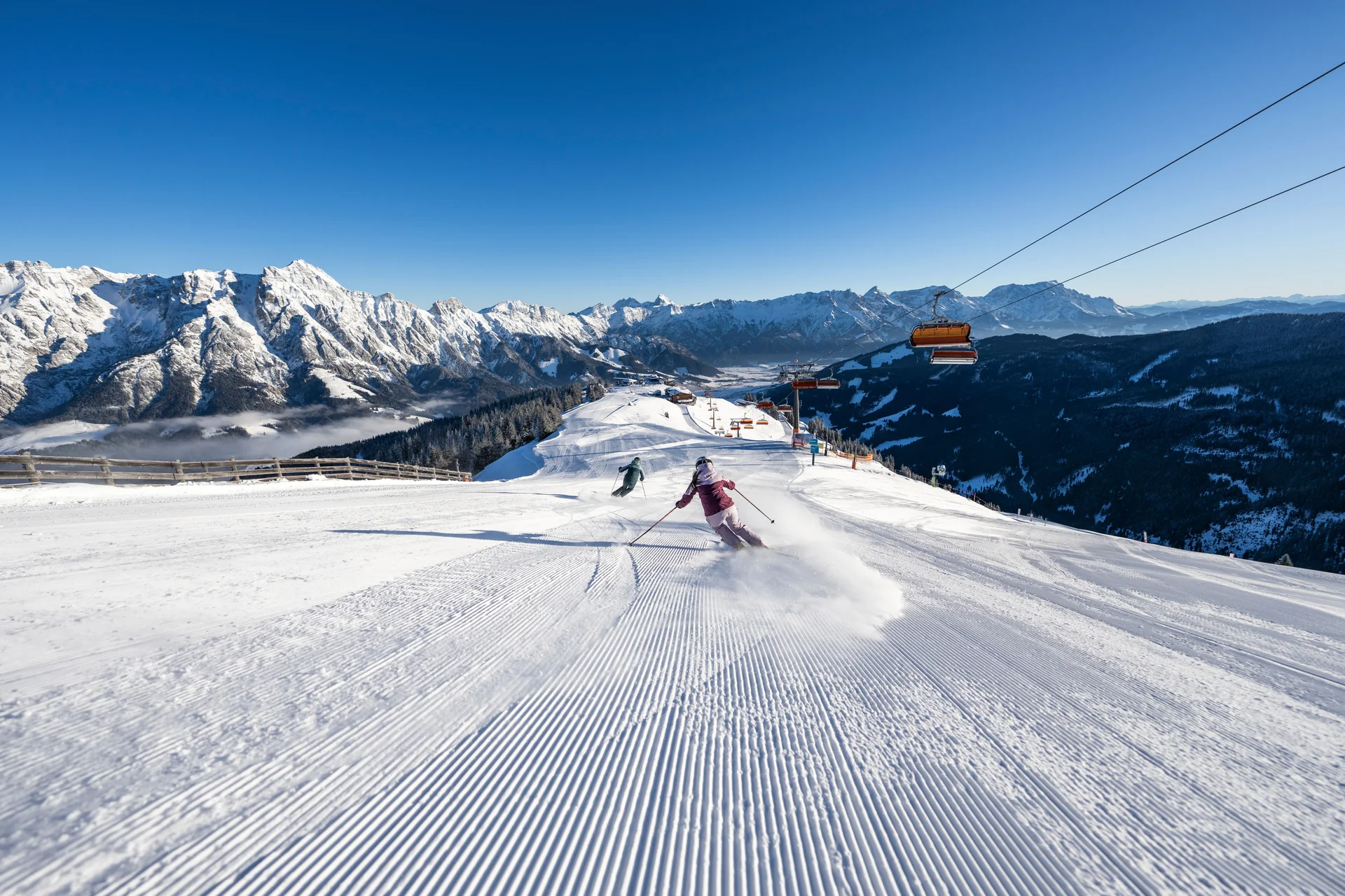 Skifahrer auf Piste am Asitz Leogang mit Steinberge-Panorama im Winter