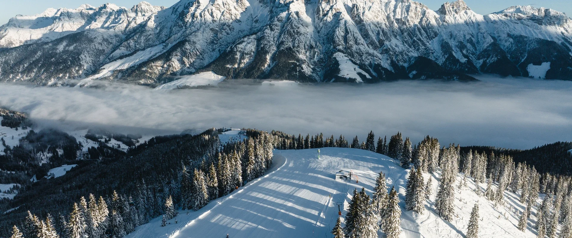 Luftaufnahme des Skigebiets über dem Nebelmeer mit Steinberge-Panorama